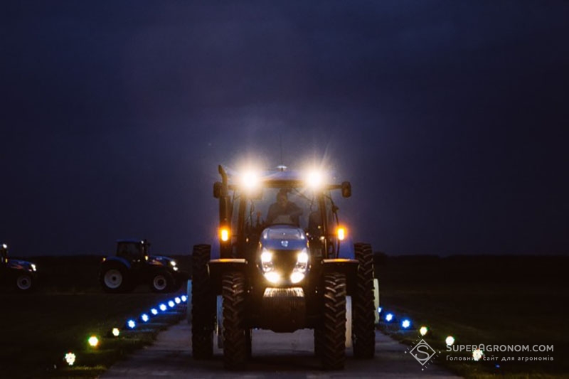 Трактори New Holland їдуть вночі